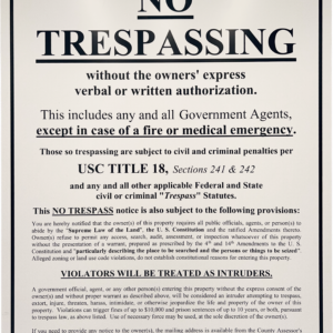 A no trespassing sign is posted on the side of a building.