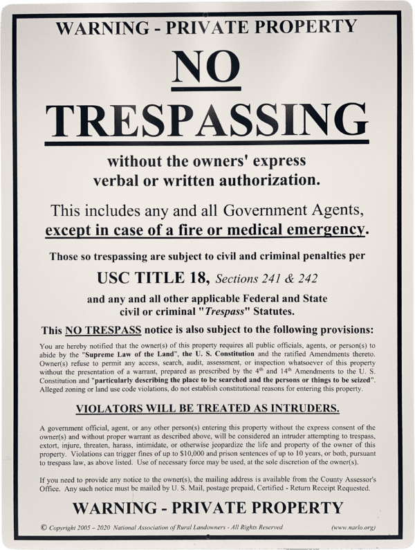 A no trespassing sign is posted on the side of a building.