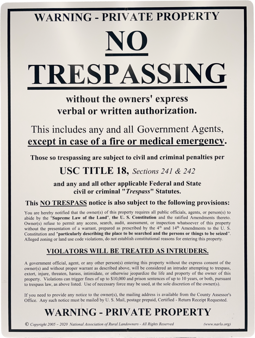 A no trespassing sign is posted on the side of a building.