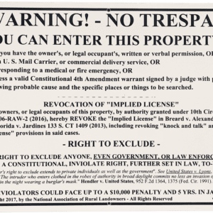 A notice warning of no trespassing is posted on the side of a building.