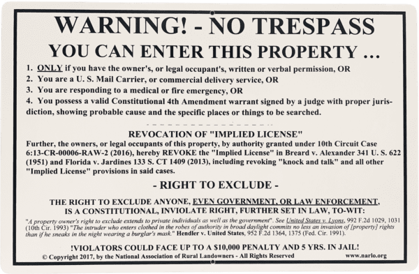 A notice warning of no trespassing is posted on the side of a building.